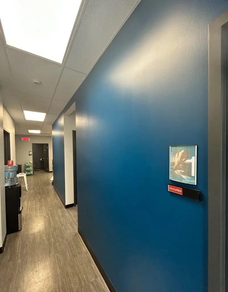 A commercial hallway with freshly painted blue accent walls and clean finishes, completed by Pro Paint Plus in Montreal, QC.