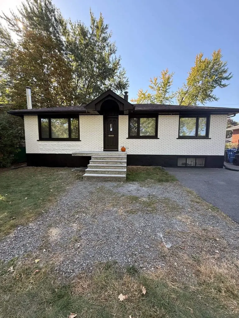 Modern white brick bungalow transformation featuring black trim and foundation painting by Pro Paint Plus.