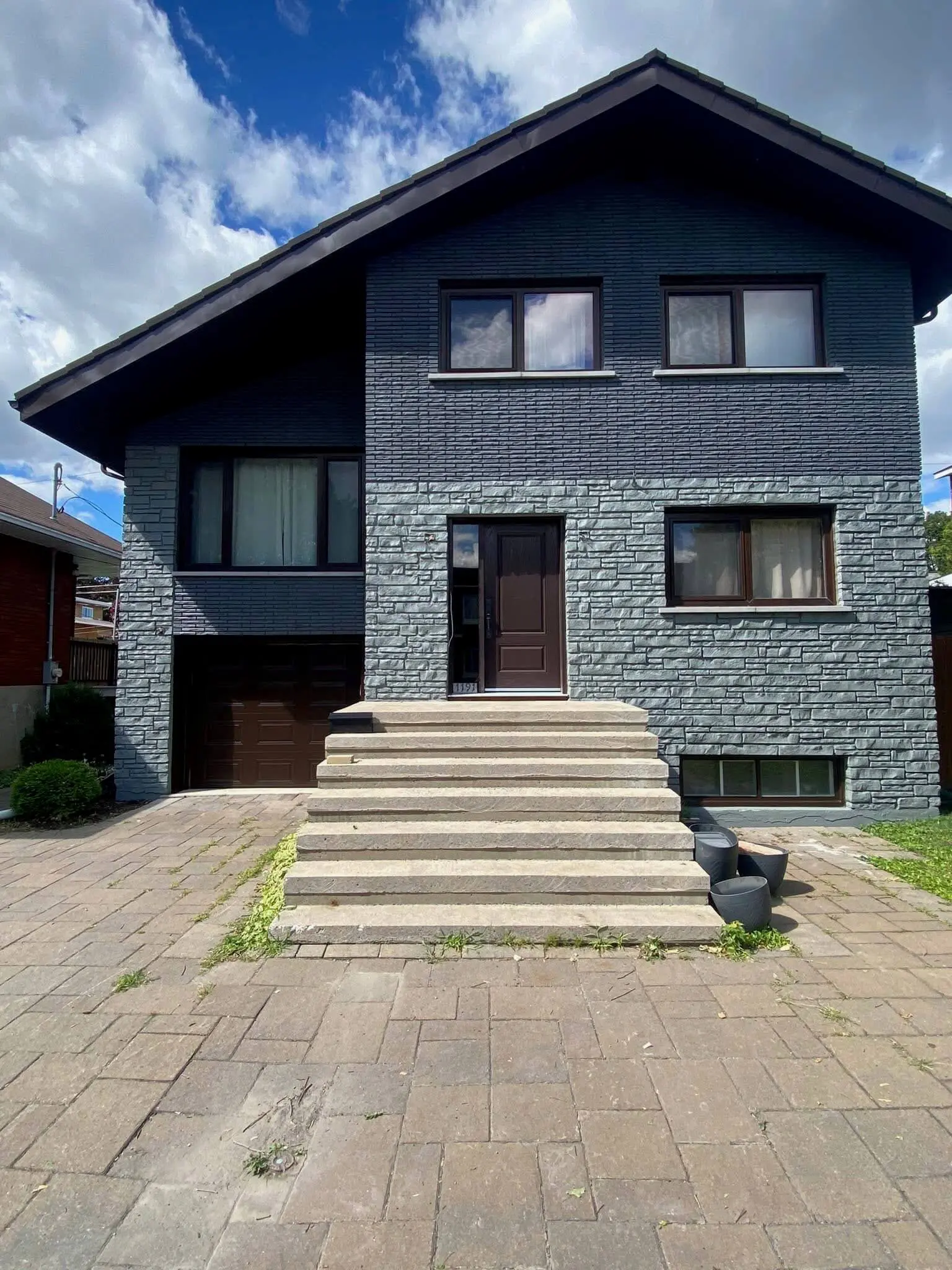 Modern residential exterior featuring a two-tone charcoal and grey stone finish professionally updated by Pro Paint Plus.