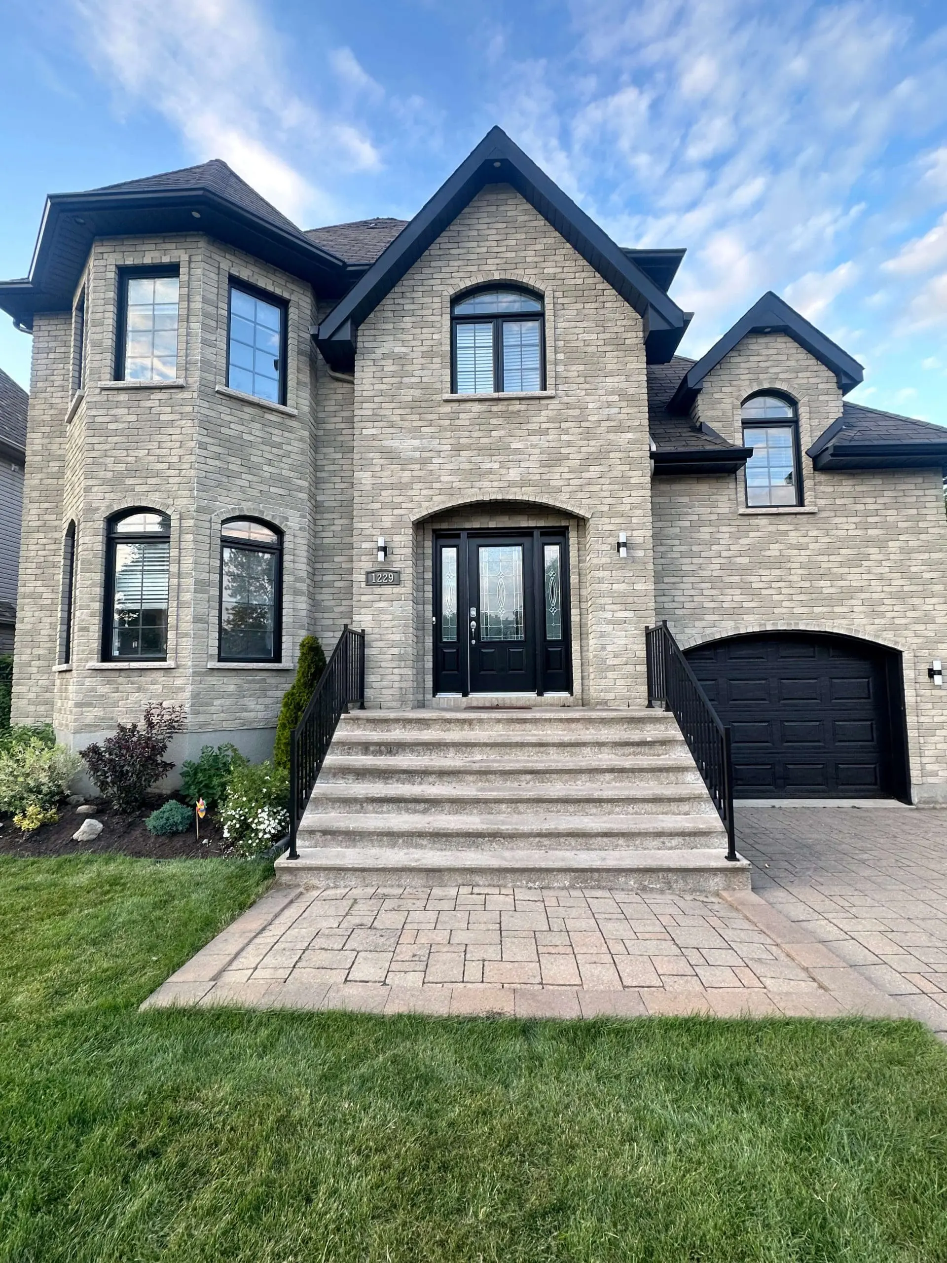 Luxury brick estate featuring custom black window frames and exterior trim finishes expertly applied by Pro Paint Plus.
