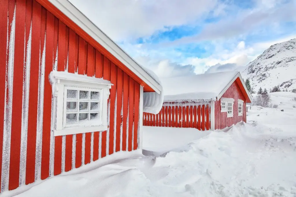 Maisons en bois rouge dans un paysage hivernal enneigé de Montréal sous un ciel bleu