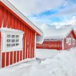 Maisons en bois rouge dans un paysage hivernal enneigé de Montréal sous un ciel bleu